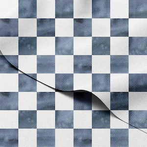 Puede incluir: Primer plano de una tela con un patrón de cuadros azules y blancos. La tela parece ligeramente texturizada, con una sección doblada, revelando una sombra oscura debajo. El efecto general es un diseño clásico pero moderno.