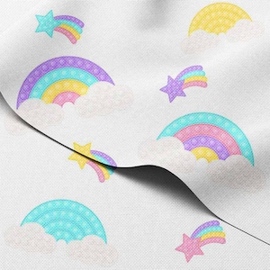 Puede incluir: Tela blanca con un patrón repetido de arcoíris, estrellas y nubes de colores. Los arcoíris son en tonos morado, azul, amarillo y rosa. Las estrellas son moradas y amarillas, con estelas de arcoíris. Las nubes son blancas.