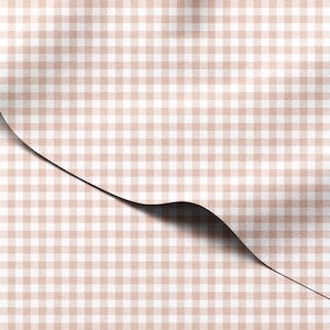May include: A close-up of a fabric with a tan and white gingham pattern. The fabric is folded over, revealing a shadow underneath. The pattern is a classic, small-scale check design.