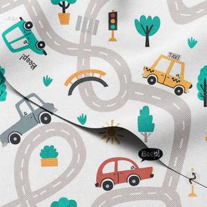 May include: White fabric with a repeating pattern of cartoon cars, roads, trees, and a bridge. Cars are in teal, yellow, gray, and red. The roads are gray with white dashed lines. The word "Beep!" is in a speech bubble.