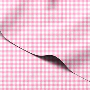 Może przedstawiać: Zbliżenie różowo-białej tkaniny w kratę gingham. Tkanina jest złożona, odsłaniając cień pod spodem. Wzór to klasyczny wzór w kratę o miękkim, teksturowanym wyglądzie.
