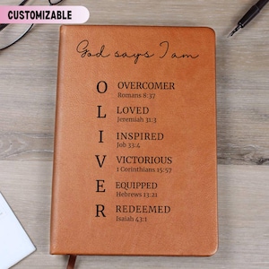 May include: A brown leather journal with the words "God says I am" and the acronym "OLIVER" with corresponding inspirational words and Bible verses. The journal has a customizable label in the upper left corner.