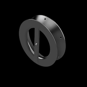 May include: A dark gray, metallic, circular object with an oval-shaped opening and a vertical bar bisecting the oval. The object has a cylindrical outer ring and several small holes. The background is solid black.
