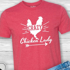 May include: Red t-shirt with a white silhouette of a chicken and the text "Crazy Chicken Lady" with an arrow pointing to the right.