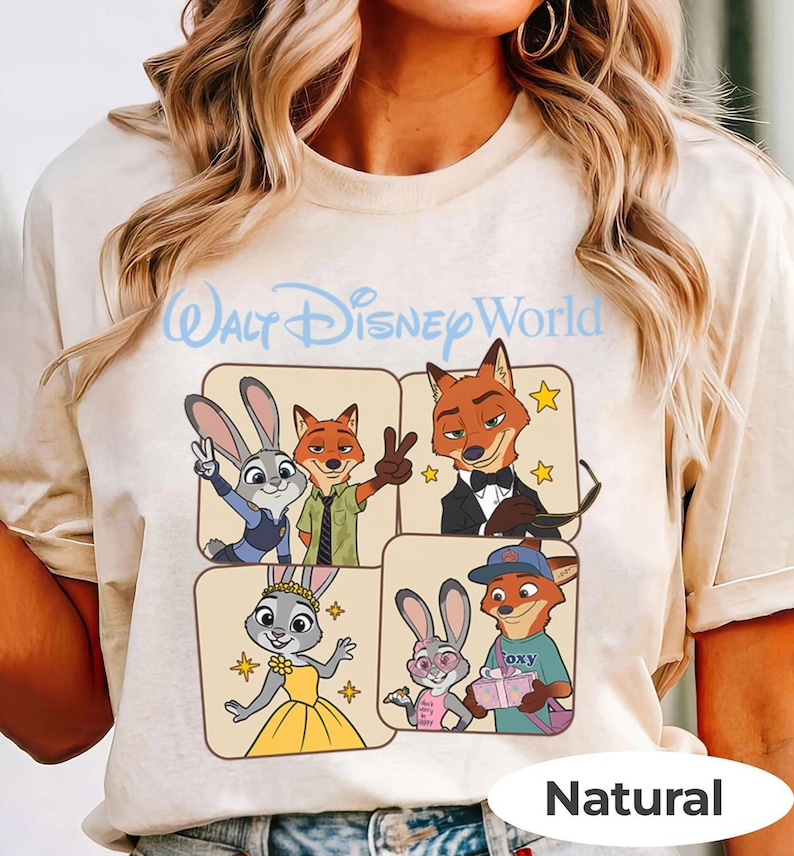 Puede incluir: Camiseta beige con un gr&aacute;fico de personajes de Zootopia y el texto "Walt Disney World" en azul claro. El dise&ntilde;o incluye a Judy Hopps y Nick Wilde en varias poses. La palabra "Natural" est&aacute; impresa en la parte inferior.