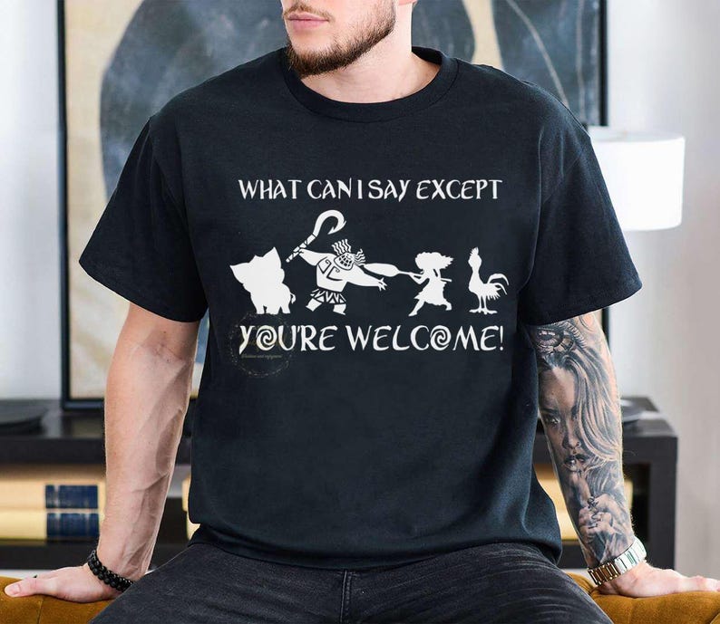 Puede incluir: Camiseta negra con un dise&ntilde;o gr&aacute;fico blanco con personajes y texto de la pel&iacute;cula "Vaiana". El texto dice "WHAT CAN I SAY EXCEPT YOU'RE WELCOME!" en una fuente divertida. El dise&ntilde;o incluye un cerdo, Maui y un gallo.