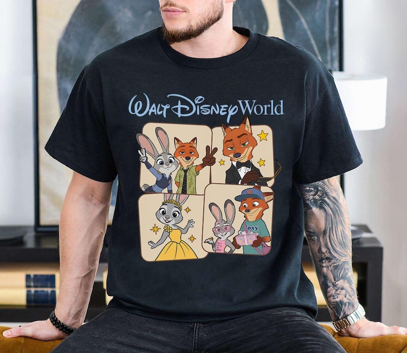 Puede incluir: Camiseta negra con un dise&ntilde;o gr&aacute;fico de personajes de la pel&iacute;cula Zootr&oacute;polis, incluyendo a Judy Hopps y Nick Wilde, con el texto "Walt Disney World" en azul claro. El dise&ntilde;o est&aacute; en formato de cuadr&iacute;cula con cada personaje en un cuadrado separado.