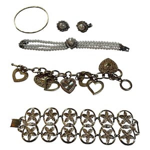 May include: A collection of jewelry including a thin gold-tone bangle, two pearl stud earrings, a three-strand pearl bracelet with a central pearl accent, a gold-tone charm bracelet with heart motifs and a watch, and a gold-tone star link bracelet.