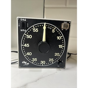 May include: A black and white GraLab timer with a large circular dial and a black knob. The timer has a power button and a focus button. The dial shows numbers from 0 to 60. The timer is made in the USA.