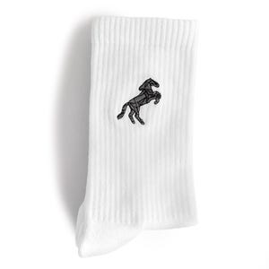 Könnte beinhalten: Eine weiße, gerippte Socke mit einem schwarzen, gestickten geometrischen Pferdemotiv. Das Pferd ist in einer steigenden Position dargestellt und mit scharfen, kantigen Linien gezeichnet, die eine facettierte, origamiartige Optik erzeugen.