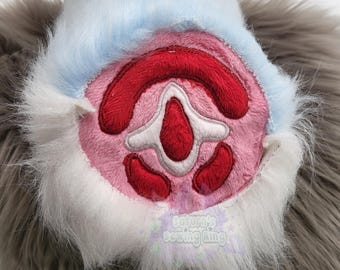 May include: Close-up of a plush paw pad with a pink center, red accents, and white details. The paw is surrounded by gray and white faux fur, with a light blue border. The text "Saturn's sewing king" is visible.