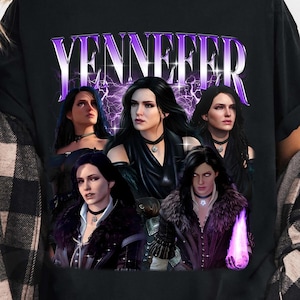 May include: Black t-shirt featuring a graphic of the character Yennefer from The Witcher series. The design includes multiple images of the character with the name "Yennefer" in a purple, stylized font. The shirt is a casual wear item.