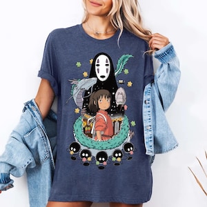 Może przedstawiać: Koszulka w kolorze granatowym z nadrukiem graficznym postaci z filmu animowanego Spirited Away. Grafika przedstawia Chihiro, Bez Twarzy i ducha rzeki.