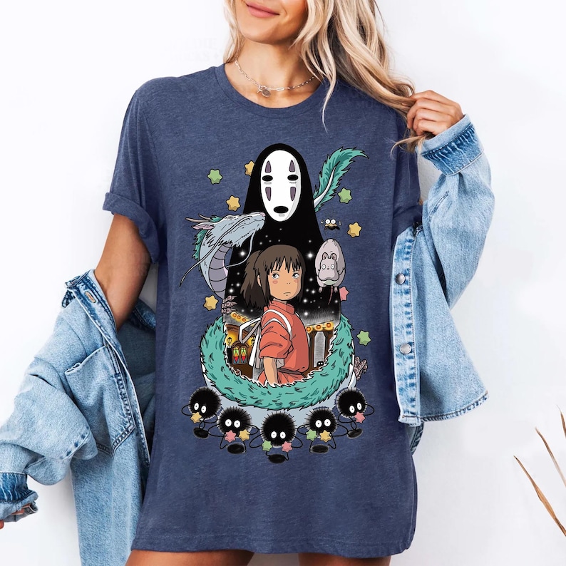 Może przedstawiać: Koszulka w kolorze granatowym z nadrukiem graficznym postaci z filmu animowanego Spirited Away. Grafika przedstawia Chihiro, Bez Twarzy i ducha rzeki.
