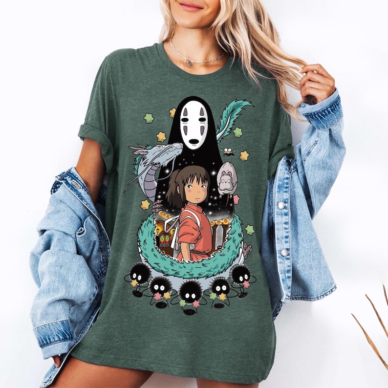 Może przedstawiać: Zielona koszulka z nadrukiem postaci z filmu animowanego Spirited Away. Postacie to Chihiro, Bez Twarzy i duch rzeki.