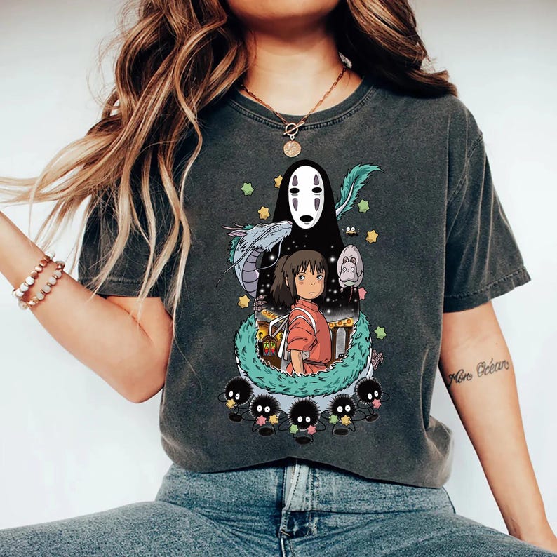 Może przedstawiać: Szary t-shirt z nadrukiem postaci z filmu animowanego Spirited Away. Postacie to Bez Twarzy, Chihiro i sadze.