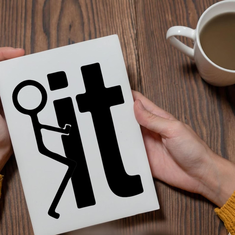 May include: A white card with the word "fit" in black, with a stick figure graphic. The card is held in front of a wooden surface, with a white mug in the background.