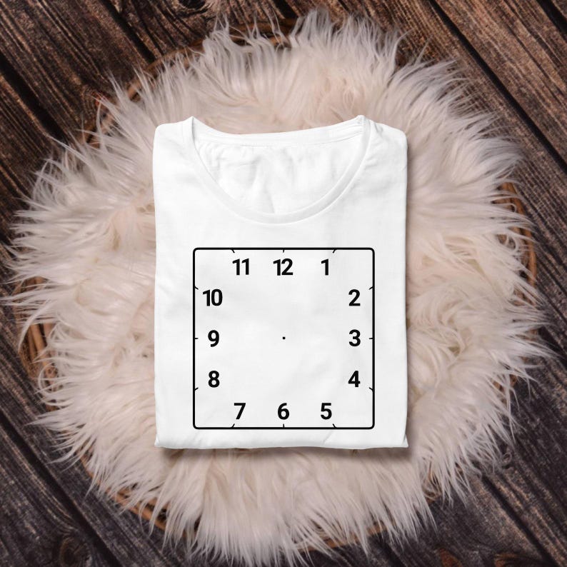 May include: White t-shirt with a black outline of a clock face with numbers 1 through 12.