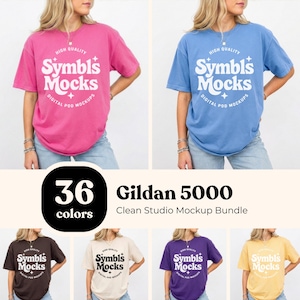 Może przedstawiać: Pakiet mockupów koszulek Gildan 5000 w różnych kolorach, w tym różowym, niebieskim, brązowym, beżowym, fioletowym i żółtym. Każda koszulka ma logo "Symbls Mocks". Obraz wyświetla również tekst "36 kolorów" i "Clean Studio Mockup Bundle".