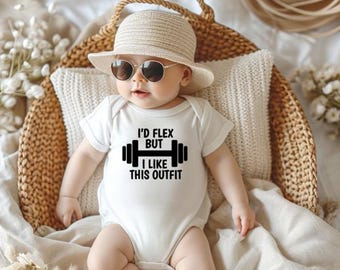 May include: A baby wearing a white onesie with the text "I'D FLEX BUT I LIKE THIS OUTFIT" and a black barbell graphic. The baby is wearing a straw hat and sunglasses, and is sitting in a woven basket.