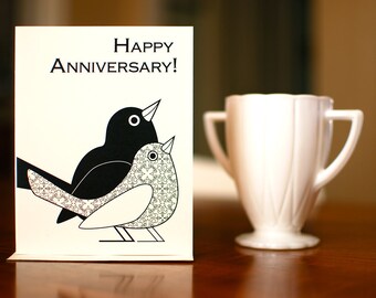 Tarjeta de aniversario "Happy Lovebirds" en blanco y negro sobre papel 100 % reciclado.
