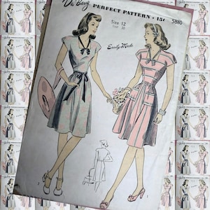 May include: A vintage Du Barry sewing pattern envelope, number 5880, size 12, bust 30. The illustration features two women wearing short-sleeved dresses with collars and waist ties. One dress is light blue with floral accents, the other is pink and striped.