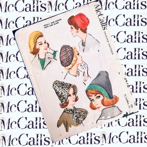 Może przedstawiać: Wzorzec szycia vintage McCall's dla pań i dziewcząt na kapelusze i szaliki. Wzorzec przedstawia cztery różne style kapeluszy, w tym kapelusz typu cloche z nadrukiem lamparta, beret w kratę, czapkę z daszkiem w kolorze szarym i czerwony kapelusz typu pillbox.
