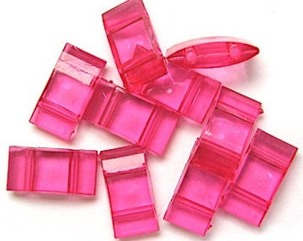 Könnte beinhalten: Eine Gruppe von zehn rechteckigen Perlen aus rosa Kunststoff mit einem Loch in der Mitte. Die Perlen sind durchscheinend und haben eine glänzende Oberfläche.