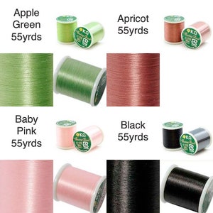 K&ouml;nnte beinhalten: Eine Auswahl an Garnspulen in den Farben Apfelgr&uuml;n, Apricot, Babyrosa und Schwarz. Jede Spule ist mit dem Farbnamen und "55 yds" beschriftet. Das Garn ist eng gewickelt, wodurch seine Textur und sein Glanz hervorgehoben werden.