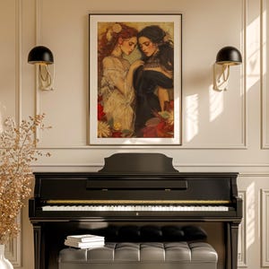 May include: A framed art print featuring two women in a romantic, classical style. One woman has red hair and wears a cream-colored dress, while the other has dark hair and wears a black dress. The artwork is set against a floral background.