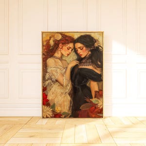 May include: A framed painting featuring two women in elegant attire. One woman has red hair and wears a cream-colored dress, while the other has black hair and wears a black dress. The artwork is surrounded by floral elements.
