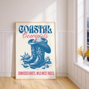 May include: A white poster with blue and red text that reads "Coastal Cowgirls" and a drawing of a blue cowboy boot with a brown cowboy hat. The text at the bottom reads "Sunkissed Boots, Wild West Roots."