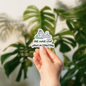 May include: A white sticker featuring a cartoon dog resting on a green pillow. The dog is gray and white. The sticker has the text "lIke mAtE sTop proCrAsTiNaTiNg" in black letters.