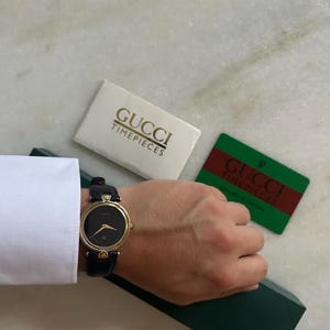 Gucci 4500 M uniseks horloge – 32 mm tweekleurig roestvrij staal en goud – zwarte wijzerplaat – Zwitsers quartz – leren band – met doos – nieuwe batterij
