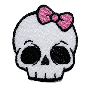 Puede incluir: Cráneo blanco con un lazo rosa en la parte superior. El cráneo tiene ojos negros y un contorno negro.