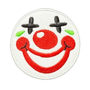 Könnte beinhalten: Gestickter Aufnäher mit einem lächelnden Clown-Gesicht. Das Design umfasst eine große rote Nase, einen roten, lächelnden Mund, schwarze kreuzförmige Augen und grüne Akzente. Der Aufnäher ist kreisförmig und hat einen weißen Hintergrund.