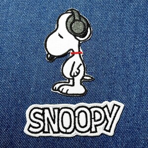 May include: Embroidered patch featuring Snoopy wearing headphones and a red collar. The patch is white with black outlines and details. Below Snoopy is a rectangular patch with the name "SNOOPY" in bold, black letters with a white outline.