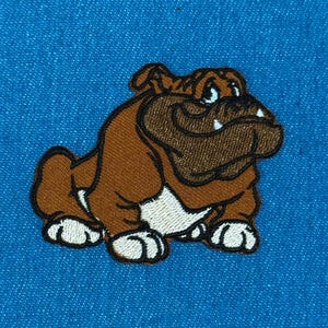 May include: An embroidered patch featuring a brown bulldog with a dark brown face, white chest, and white paws. The bulldog has a wrinkled snout, visible white teeth, and is positioned against a solid, bright blue textured fabric background.