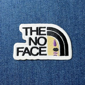 May include: Embroidered patch with the text "THE NO FACE" in black block letters. The design includes a stylized face with a black and white arched shape, a tan face, and purple details.