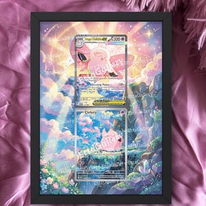 May include: A black framed print featuring two Pokémon trading cards. The cards are displayed against a colorful background with a sky and floral design. The text "cards are not included" is at the bottom.