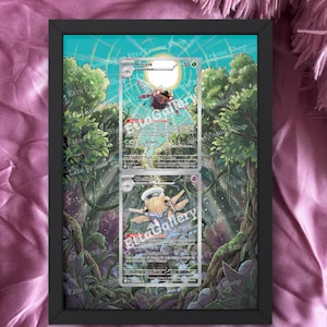 Può includere: Un'opera d'arte incorniciata con due carte Pokémon, Ninjask e Shedinja, su uno sfondo di giungla. La cornice è nera e le carte sono esposte con i loro dettagli visibili. Il testo "cards are not included" è in basso.