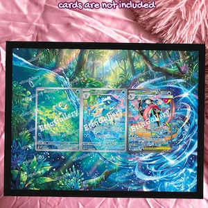 May include: A framed print featuring three Pokémon trading cards with water-themed artwork. The cards are set against a vibrant, blue and green background with the text "cards are not included" at the top.