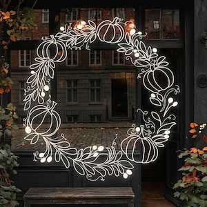 Pode incluir: Um autocolante de arte linear branca com uma coroa circular que apresenta quatro abóboras, ramos com folhas e pequenas bagas. O design é aplicado numa superfície de vidro, criando uma decoração sazonal com contornos bem definidos.