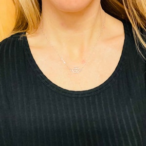 May include: A silver chain necklace with a delicate, open circle pendant.