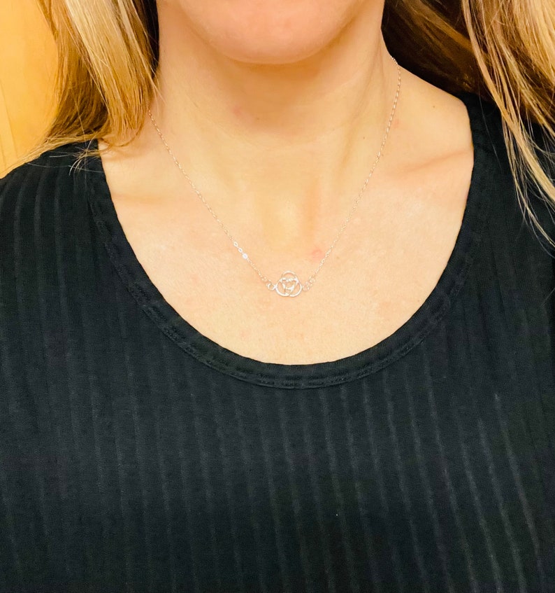 May include: A silver chain necklace with a delicate, open circle pendant.