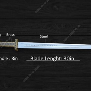 May include: A steel sword with a brass handle and stone accents. The blade is 30 inches long, and the handle is 8 inches. The sword has engraved text on the blade.