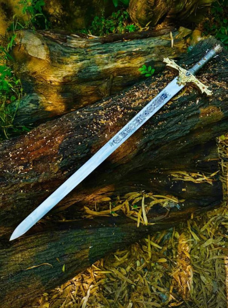 Puede incluir: Una espada larga y plateada con empu&ntilde;adura y guarda doradas, apoyada sobre un tronco desgastado. La hoja tiene un dise&ntilde;o grabado. La espada es un art&iacute;culo de fantas&iacute;a o hist&oacute;rico.