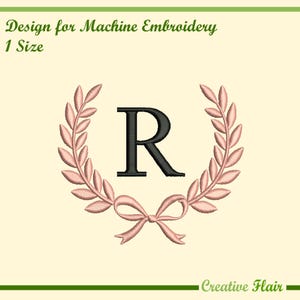 Pode incluir: Design de bordado à máquina com a letra preta "R" dentro de uma coroa de louros rosa com um laço. O design é rotulado como "Design for Machine Embroidery" e "1 Size". As palavras "Creative Flair" estão na parte inferior.