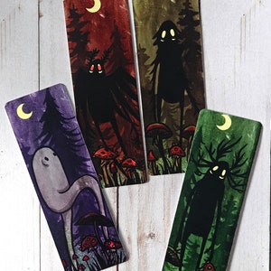 May include: Four illustrated bookmarks featuring different creatures in a forest setting. Each bookmark has a crescent moon and mushrooms. The creatures are a ghost, a creature with antlers, a creature with a long neck, and a creature with wings.