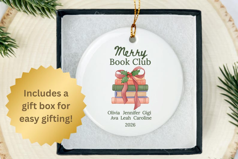 Pode incluir: Um ornamento redondo de cer&acirc;mica branca com o texto Merry Book Club acima de uma ilustra&ccedil;&atilde;o de uma pilha de livros amarrados com uma fita vermelha e azevinho. Abaixo dos livros est&atilde;o os nomes Olivia, Jennifer, Gigi, Ava, Leah, Caroline e 2026.